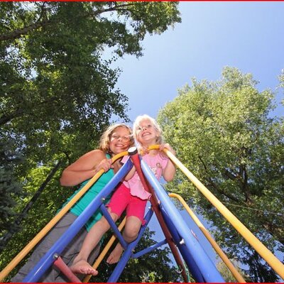 Zwei Kinder spielen auf dem Spielgerüst im Außenbereich des Bauernhofs.