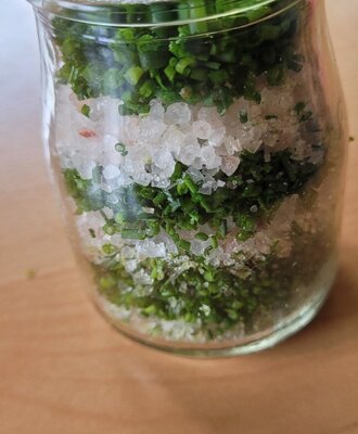 Glas mit Schnittlauch und Salz.