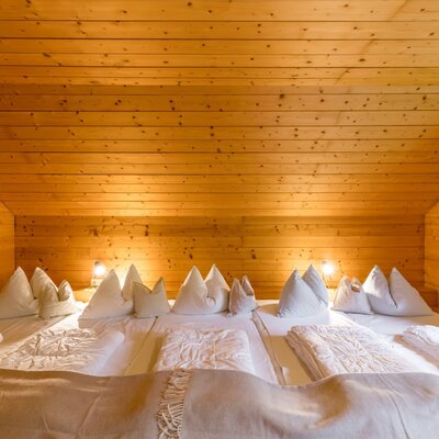 Schlafzimmer 1 der Scharlinger Alm am Hauser Kaibling mit gemütlicher Einrichtung für den Hüttenurlaub. © Elisabeth Fröhlich