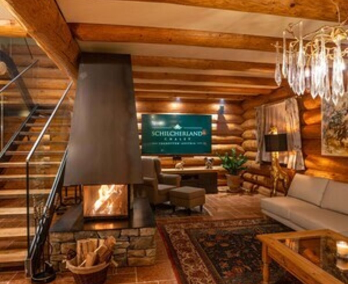 Der gemütliche Wohnbereich des Ferienhauses mit einem modernen Kamin, freiliegenden Holzbalken und einladenden Sitzgelegenheiten.