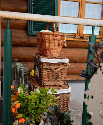 Der einladende Eingangsbereich des Ferienhauses, dekoriert mit charmanten Weidenkörben und herbstlichen Pflanzkübeln.