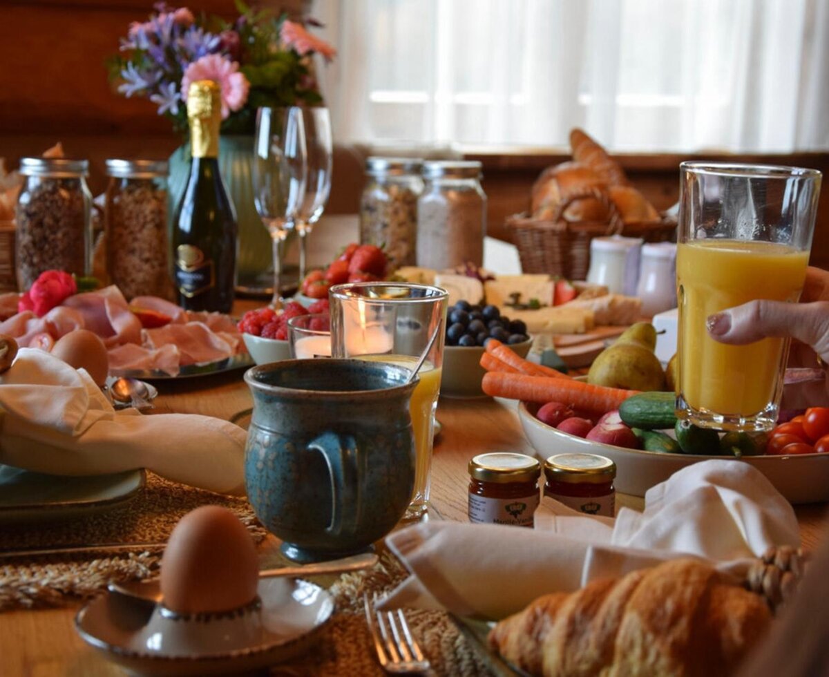 Ein reichhaltiges und einladendes Frühstück im Ferienhaus mit frischem Saft, Gebäck und einer feinen Auswahl an Leckereien.