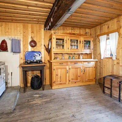 Der Kochbereich im Hof ist mit einem Küchenherd, einem Holzschrank und einer Holztruhe ausgestattet.