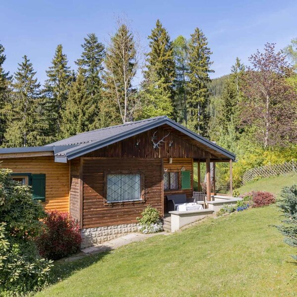 Außenansicht des Bed and Breakfast mit Holzfassade, Veranda und umgebender Natur.