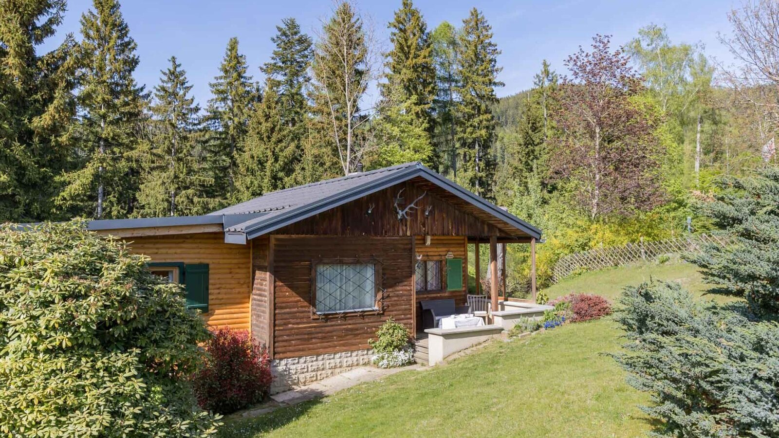 Außenansicht des Bed and Breakfast mit Holzfassade, Veranda und umgebender Natur.