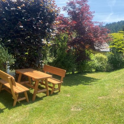 Sitzgelegenheit mit Holzbänken und einem Tisch bei der Birken Ferienwohnun