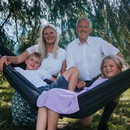 Familie Zettler in einer Hängematte im Garten.