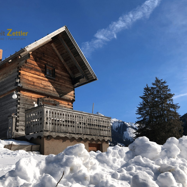 Der Troadkasten mit Balkon, umgeben von Schnee und Bergen.