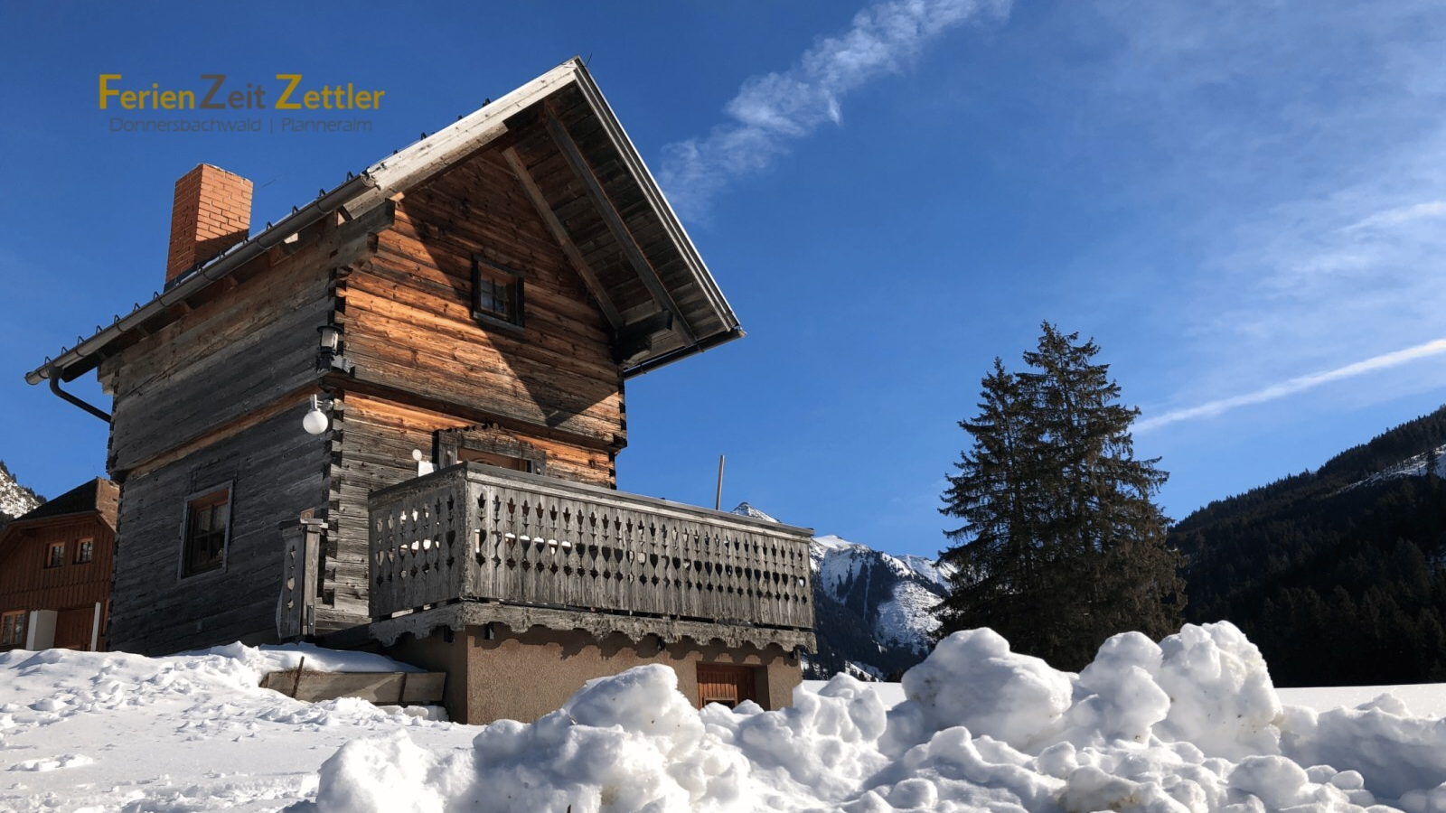 Der Troadkasten mit Balkon, umgeben von Schnee und Bergen.
