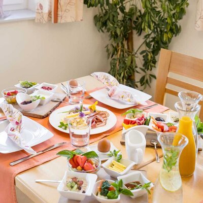 Frühstückstisch mit Wurst, Käse, Eiern, Obst, Müsli und Getränken im Bauernhof. (c) Elisabeth Fröhlich Photography
