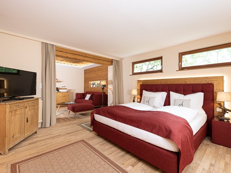 Geräumiges Doppelzimmer im Hof mit Doppelbett, separatem Wohnbereich mit Schlafsofa und Fernseher.