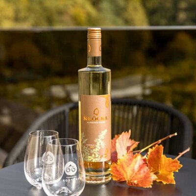 Eine Flasche Wein und zwei Gläser auf einem Tisch auf dem Balkon des Hauses, ideal für eine Weinprobe mit Blick auf die Weinberge.