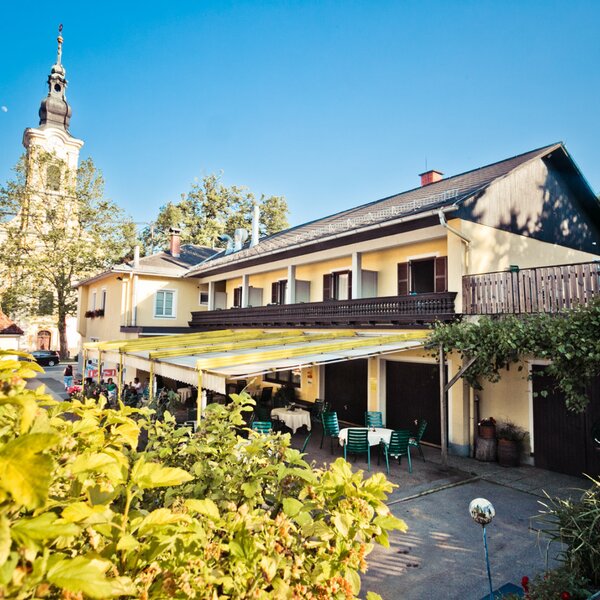 Der Hof mit Außensitzbereich, Zimmerbalkonen und einem Kirchturm im Hintergrund.