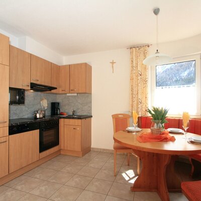 Die bestens ausgestattete Küche des Bauernhofs mit Essbereich und Fenstern mit Blick auf die Pitztaler Bergwelt.