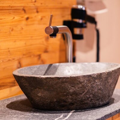 Stilvolle Details wie dieses Steinwaschbecken unterstreichen das moderne Design unseres Wellnessbereichs.