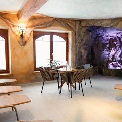 Entspannungsbereich im Wellnessbereich mit Liegen, Sitzgelegenheiten und der sogenannten "Kunerngrotte" im Hintergrund.