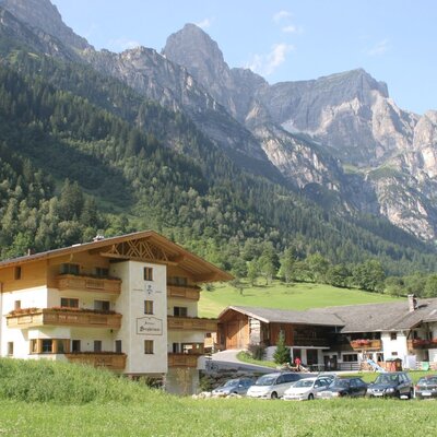 Außenansicht von Alfaierhof und der Bergheimat an einem sonnigen Sommertag im Gschnitztal.