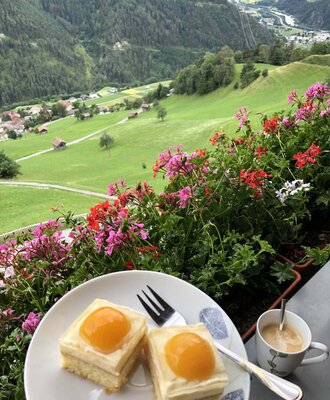Vom Balkon des Bauernhofs bietet sich eine malerische Aussicht auf die grünen Wiesen und Berge, perfekt für einen Kaffee.