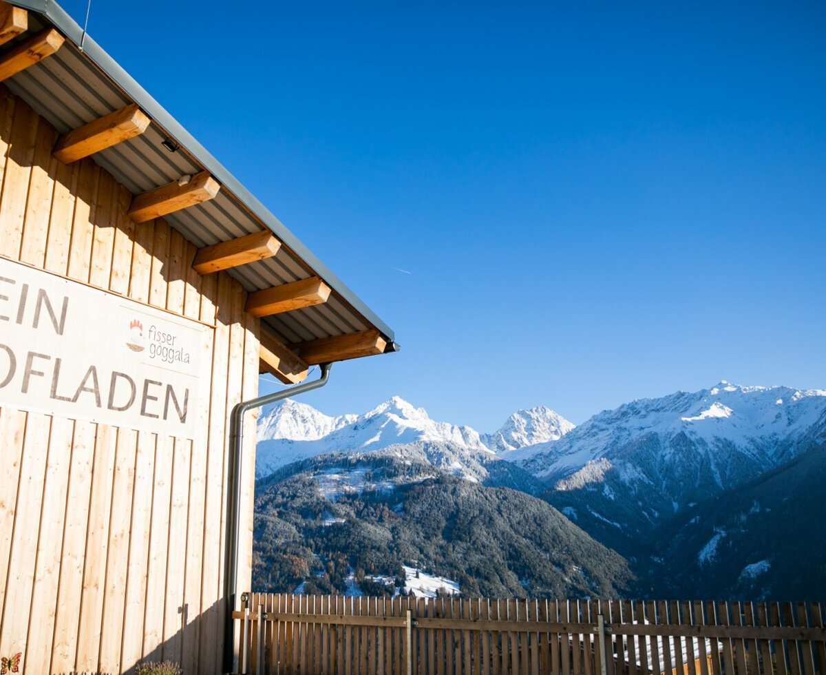 Der Hofladen der Ferienwohnung mit Blick auf die schneebedeckten Berge.