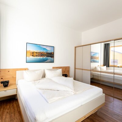 Schlafzimmer der Ferienwohnung mit Doppelbett, Nachttischen und Spiegelschrank.