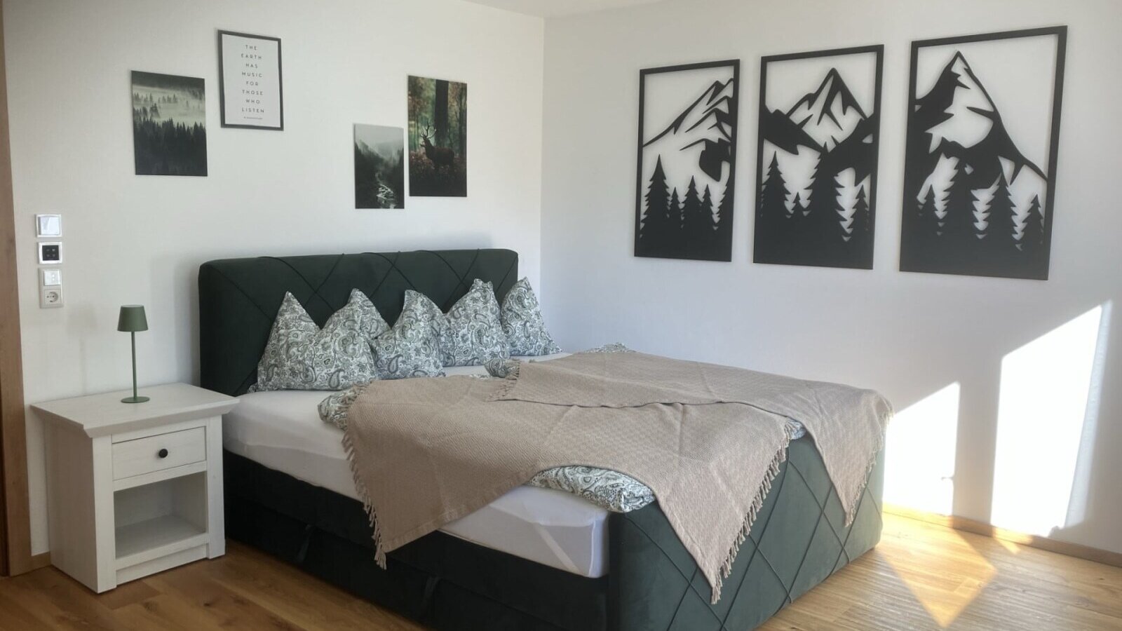 Ein einladendes Doppelzimmer im Bed and Breakfast mit einem komfortablen Boxspringbett, stilvoller Wanddekoration und hellem Holzboden.