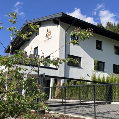 Das einladende Bed and Breakfast liegt unter strahlend blauem Himmel und ist von viel Grün umgeben.