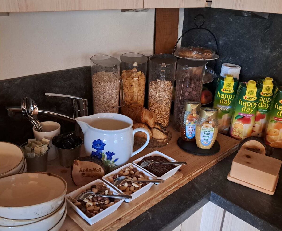 Das einladende Frühstücksbuffet des Bauernhofs mit Müsli, Nüssen, frischer Milch und einer Auswahl an Säften.