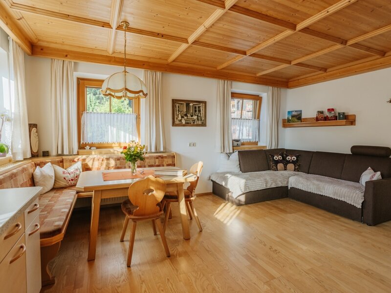 Wohn- und Küchenbereich der Ferienwohnung im Bauernhof mit Essplatz, Eckbank und Ausziehcouch.