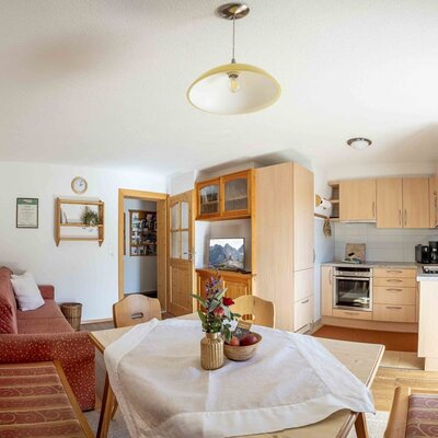 Wohn- und Küchenbereich des Bauernhofs mit Esstisch, Sofa und voll ausgestatteter Küchenzeile.