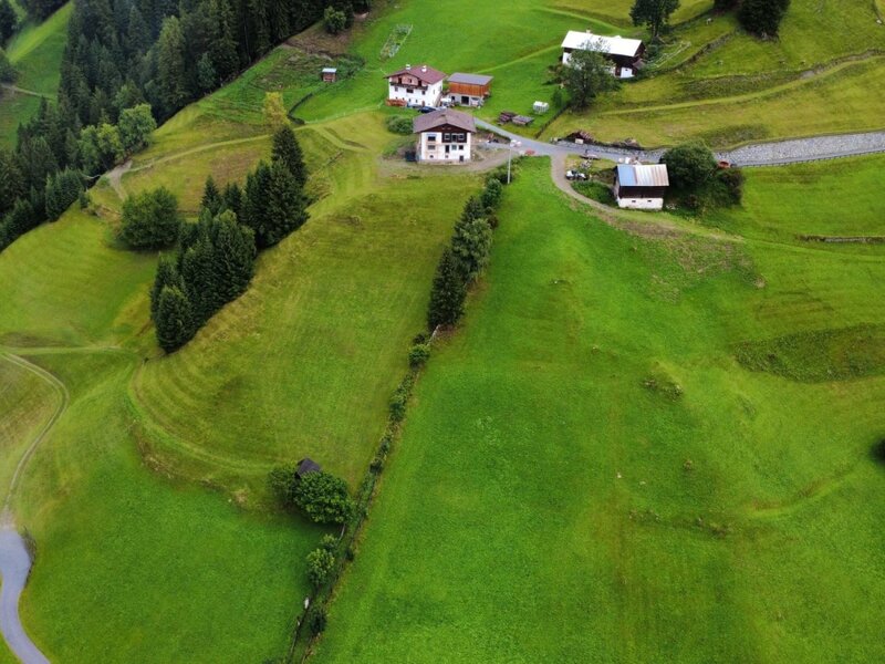 Eine Luftaufnahme der Appartements inmitten von saftig grünen Berghängen und dichten Nadelwäldern.