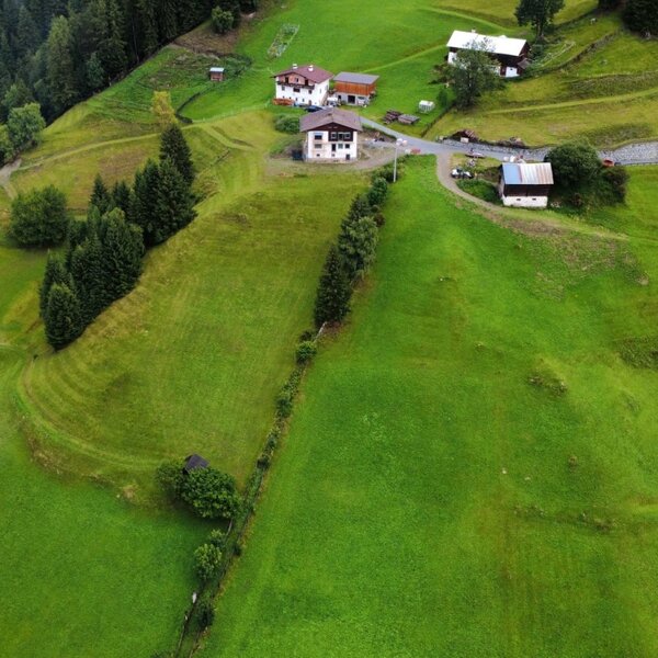 Eine Luftaufnahme der Appartements inmitten von saftig grünen Berghängen und dichten Nadelwäldern.