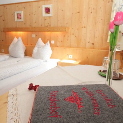 Doppelzimmer der Ferienwohnung auf dem Bauernhof mit Holzvertäfelung und Willkommensgruß.