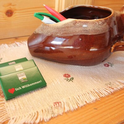 Begrüßungsgeschenke für Gäste und ein Stiftehalter auf dem Holztisch im Bauernhof.