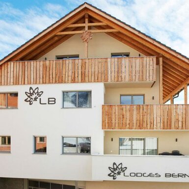 Die Außenansicht des Bauernhofs Lodges Bernardes mit Holzbalkonen und sichtbarer Dachkonstruktion aus Holz.