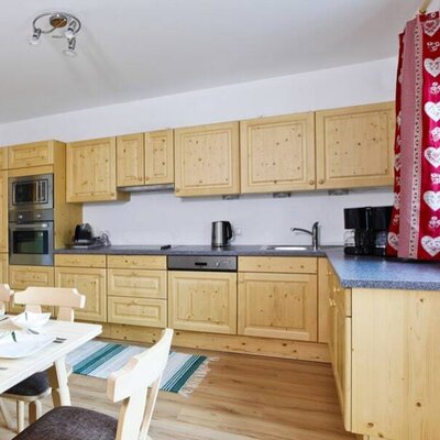 Die Küche im Bauernhof verfügt über eine Küchenzeile aus Holz, einen Backofen, eine Mikrowelle, einen Geschirrspüler und einen Essbereich.