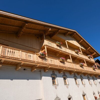 Die Holz-Balkone des Bauernhofs, geschmückt mit Blumenkästen.