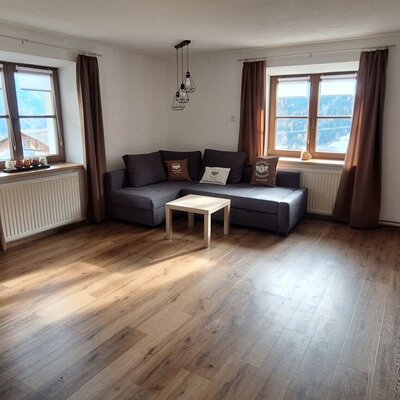 Wohnbereich des Ap­par­te­ments mit Ecksofa