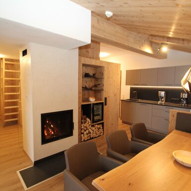 Der Wohn- und Essbereich des Bauernhofs ist mit einem Kamin, einem großen Holzesstisch, einer modernen Küchenzeile sowie einer Holzdecke und einem Holzfußboden ausgestattet.