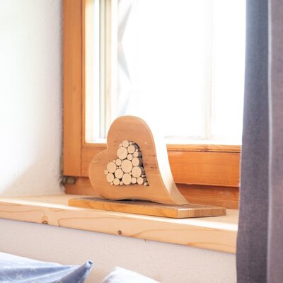 Holzherz-Dekoration auf der Fensterbank der Ap­par­te­ments.