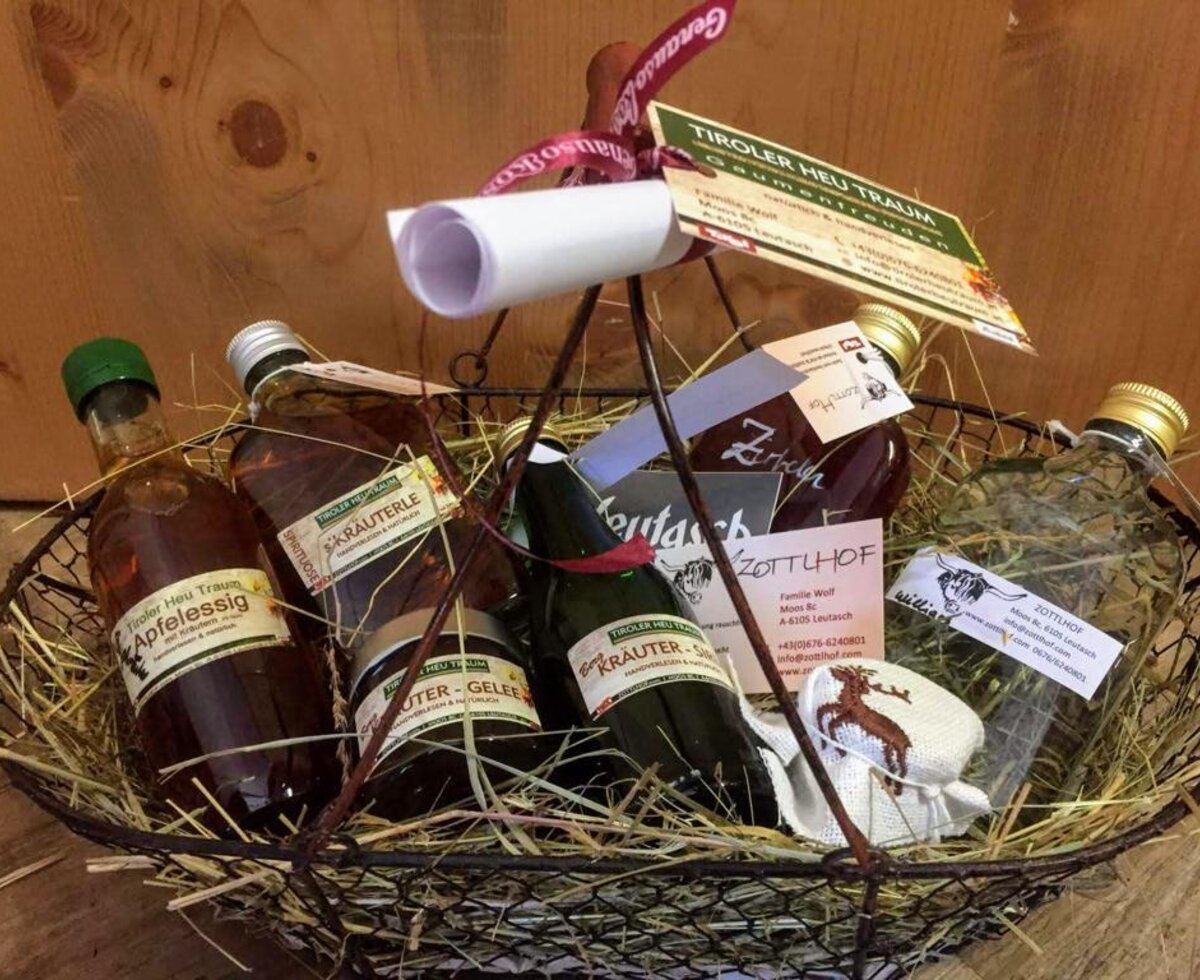 Ein liebevoll gestalteter Geschenkkorb des Appartements mit regionalen Tiroler Spezialitäten auf Heu.