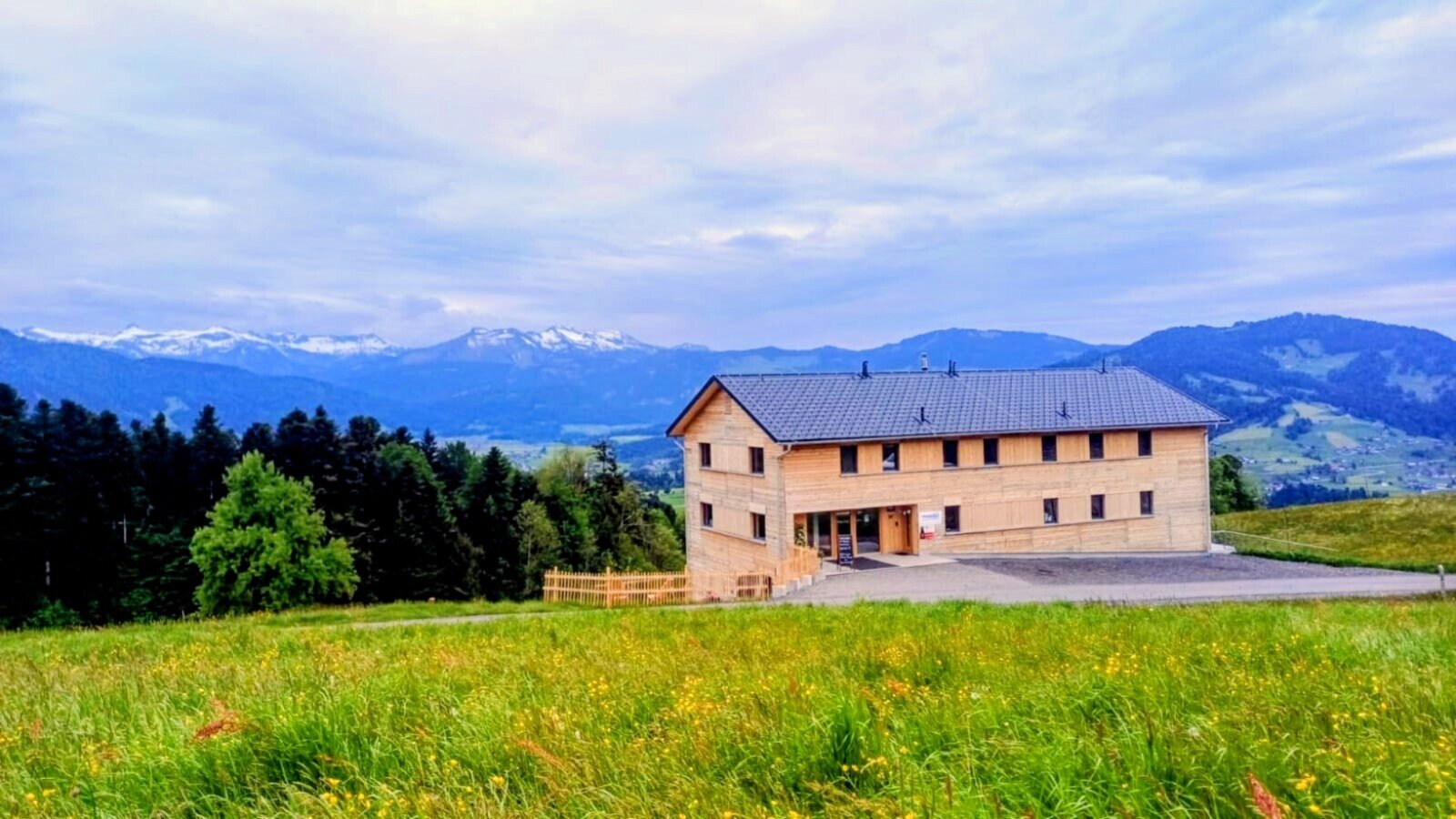 Der neu erbaute Bauernhof in idyllischer Alleinlage, umgeben von grünen Bergwiesen und mit weitem Blick auf die Alpen.