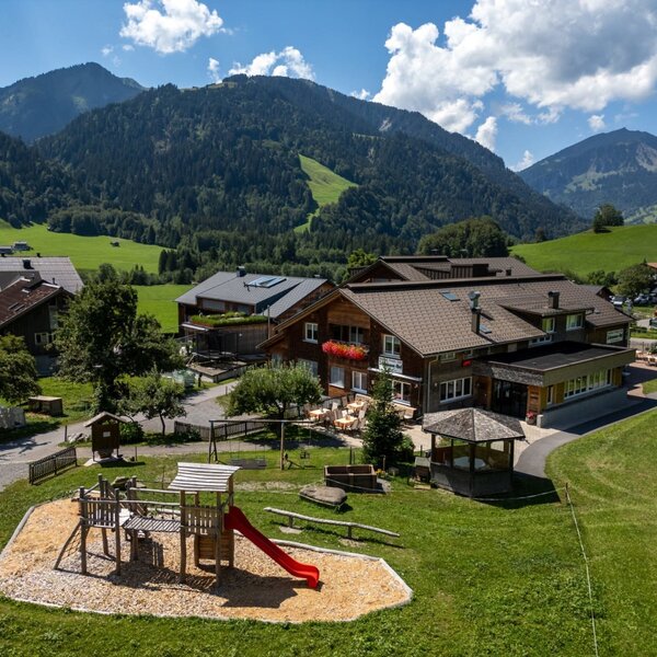 Der einladende Bauernhof mit einem weitläufigen Spielplatz vor der Kulisse der beeindruckenden Allgäuer Alpen.