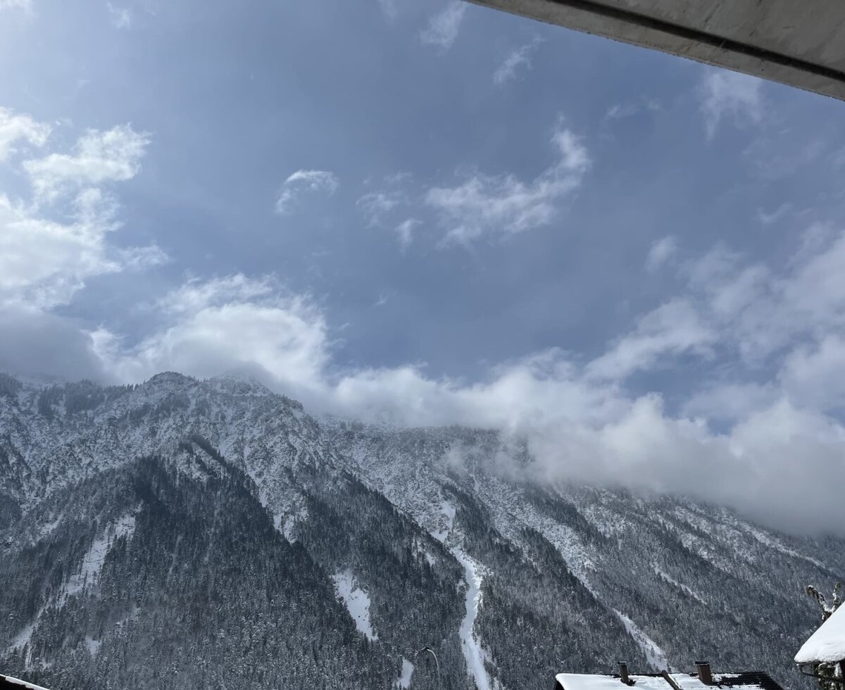 Blick auf die schneebedeckten Berge vom Bauernhof aus.