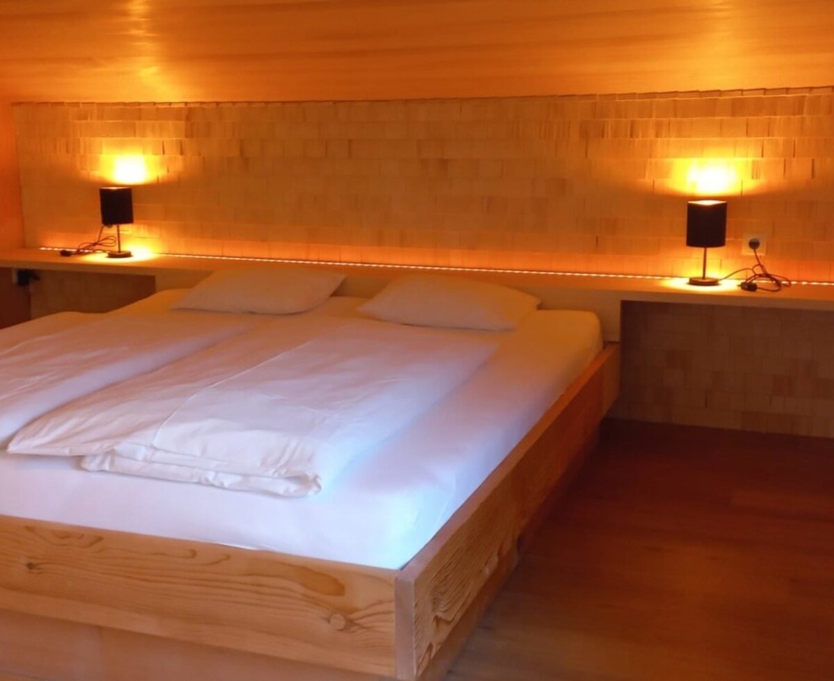 Doppelbett im Schlafzimmer in der Wohlfühlferienwohnung Seftone. Schindeln schaffen einen gemütliche Stimmung