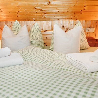 Das Schlafzimmer unserer Ferienwohnung ist mit hellem Holz und einer urigen Dachschräge.