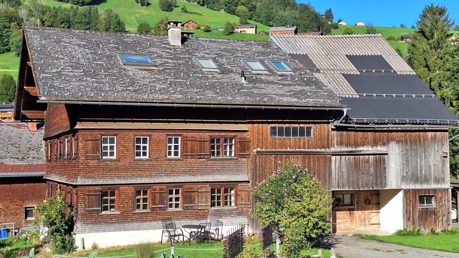 Unser Haus mit charmanter Holzfassade umgeben von Wiesen und Wäldern