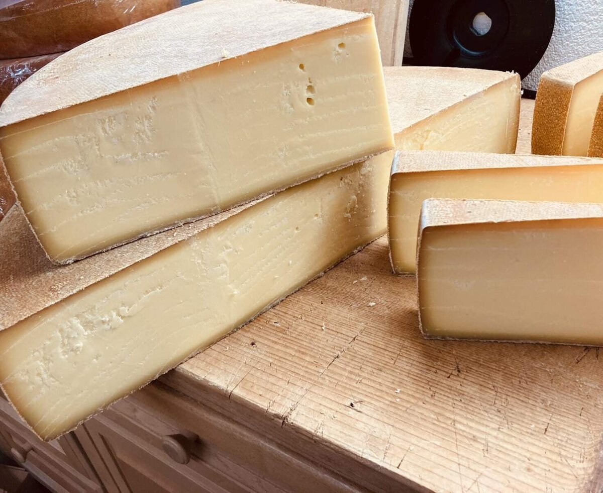 Eine Auswahl an köstlichem, regionalem Käse auf einem rustikalen Holzbrett in der Ferienwohnung.