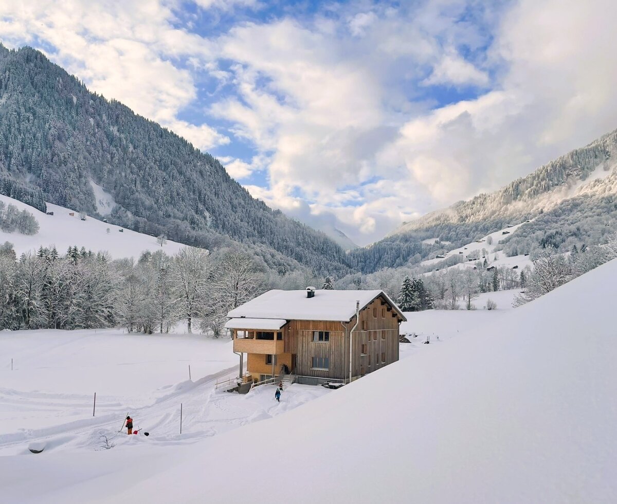 Das Gebäude mit den Ferienwohnungen inmitten einer idyllischen, tief verschneiten Winterlandschaft.
