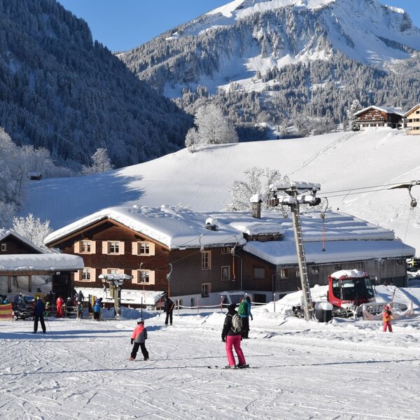 Die Skipiste mit Skilift direkt vor dem Bauernhof, umgeben von schneebedeckten Bergen. Die Skipiste mit Skilift direkt vor dem Bauernhof, umgeben von schneebedeckten Bergen.