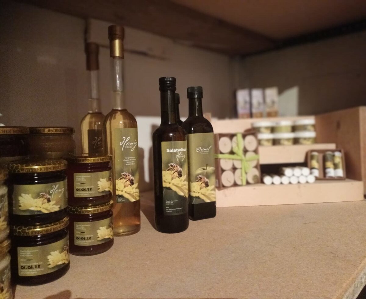 Regal mit Honigprodukten des Bauernhofs, darunter Honiggläser und Flaschen mit Honiglikör.